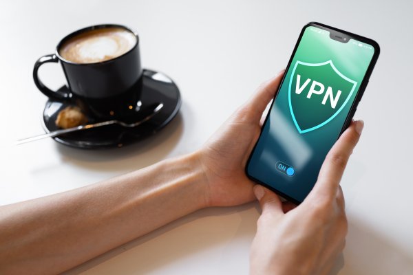 vpn on smartphone cup of coffee holding a smartphone vpn services